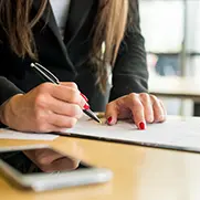 A person pointing at a document they ar signing.